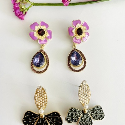 Dois pares de brincos decorativos sobre fundo branco, com flores rosas na parte superior