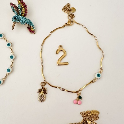 Conjunto de brincos e pulseira com pedras coloridas e pingentes temáticos