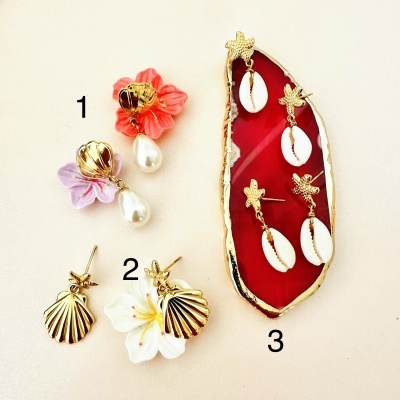 Três conjuntos de brincos dourados com flores, pérolas e conchas
