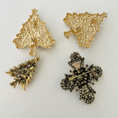 Quatro pins metálicos de Natal em fundo branco