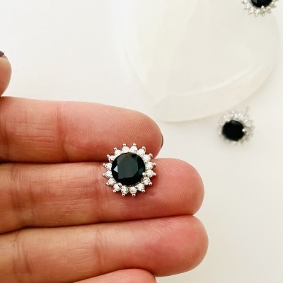 Brincos com pedra preta e pequenas pedras transparentes em base prateada