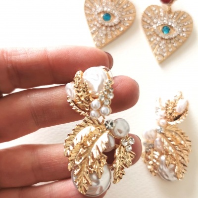 Brincos com coração dourado e pérolas azuis e brincos de folhas douradas com pérolas e cristais