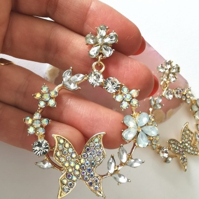 Brincos dourados com pedras e flores em close-up