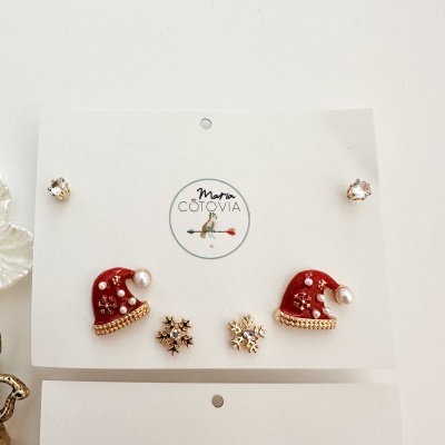 Conjunto de brincos natalícios com gorrinhos vermelhos, flocos de neve dourados e cristais