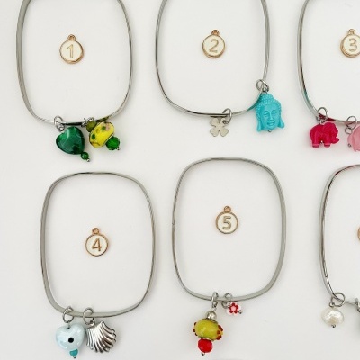 Pulseiras quadradas de metal com vários pendentes coloridos e etiquetas numeradas