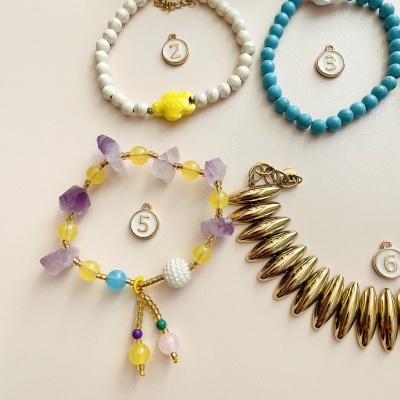Quatro pulseiras coloridas sobre fundo branco com etiquetas numeradas
