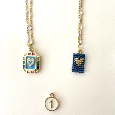 Colares dourados com pendentes coloridos e um pendente branco com número 1