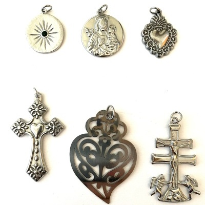 Seis medalhas religiosas prateadas numeradas de 1 a 6 sobre fundo branco