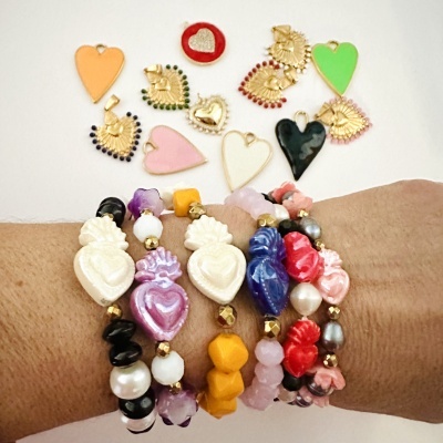 Pulseiras coloridas com contas e corações variados num braço