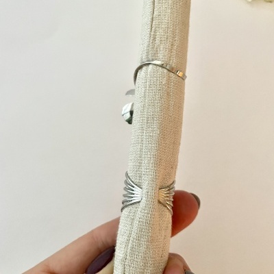 Anel duplo prateado em tecido bege para exposição