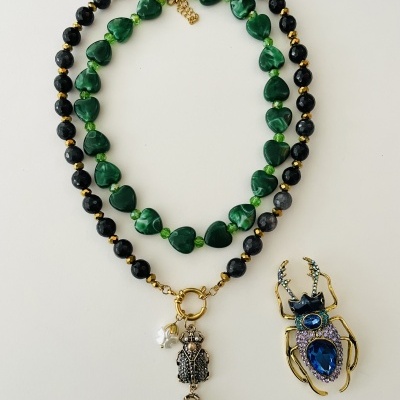 Colar de contas negras com pendentes e broche de escaravelho decorado com pedras azuis