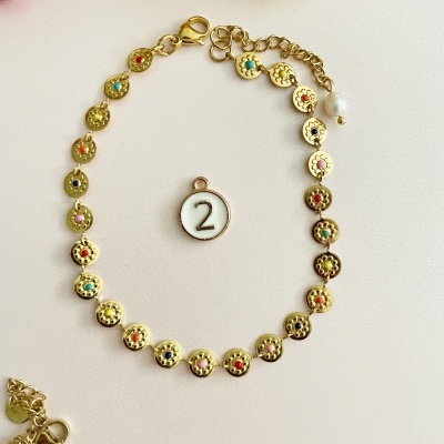 Pulseira dourada com pedras coloridas e pingente número 2