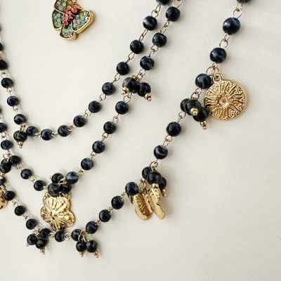 Colar com contas pretas e pendentes dourados variados