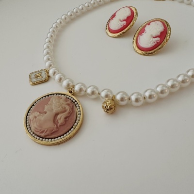 Colar de pérolas com medalhão rosa e brincos de camafeu vermelhos