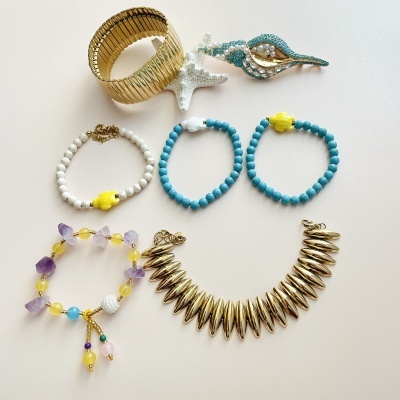 Conjunto de bijuterias coloridas e douradas com uma estrela-do-mar branca decorativa