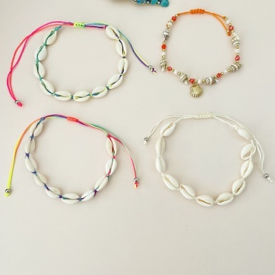 Pulseiras de búzios com cordões coloridos e broche de concha azul