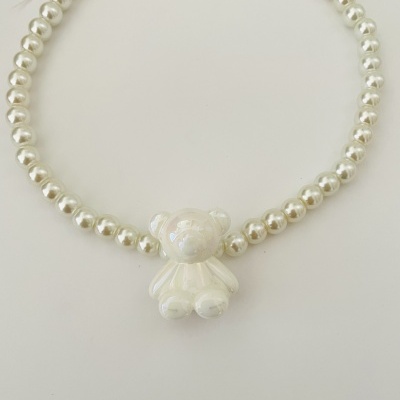 Colar de pérolas brancas com pendente de urso branco e fecho dourado