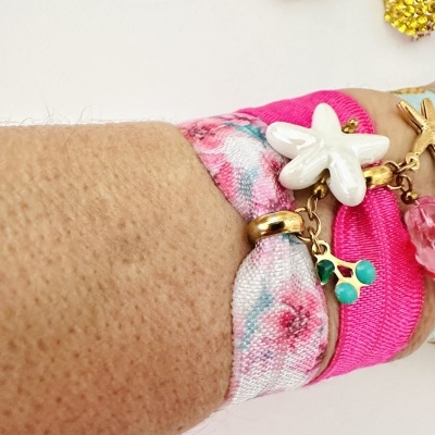 pulseiras rosa com pendentes florais em braço