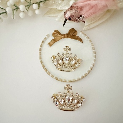 Duas coroas douradas com pedras e decoração floral branca