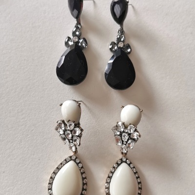 Dois pares de brincos pendentes com pedras pretas e brancas sobre fundo branco