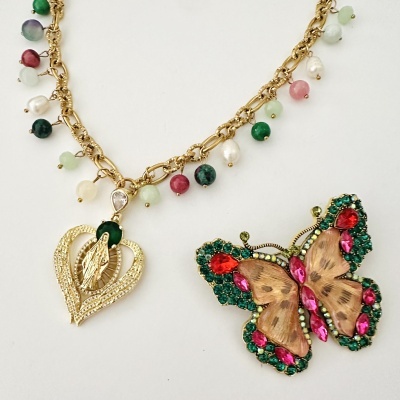 Colar dourado com pedras e broche de borboleta colorida