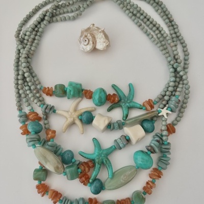 Colar decorativo com contas e estrelas do mar em vários tons de verde, branco e laranja