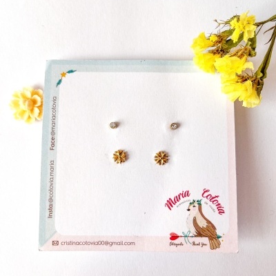 Conjunto de brincos prateados e dourados em cartão decorativo com galinha e texto Maria Cotovia