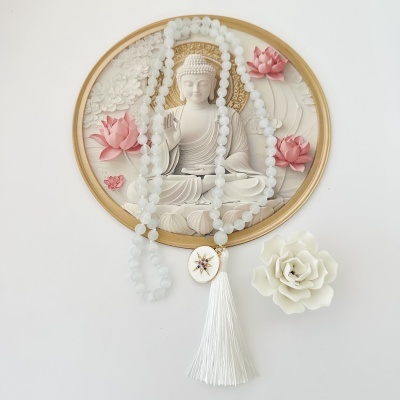 Colar branco com pendente e franjas em fundo branco com imagem de Buda e flores cor-de-rosa