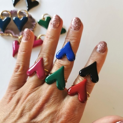 Anéis e brincos de coração coloridos em superfície branca