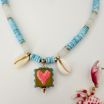 Colar com contas azuis e brancas e pendentes de conchas e cora o rosa.