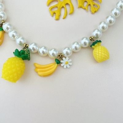 Colar com pérolas e pendentes de frutas amarelas e verde