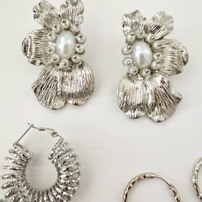 Brincos de metal prateado com design floral e argolas texturizadas