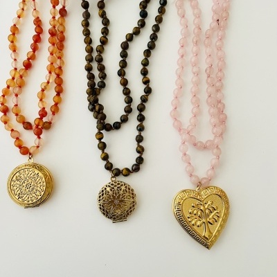 Três colares com contas coloridas e pendentes dourados variados