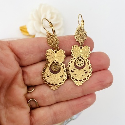 Brincos dourados com design detalhado em fundo branco