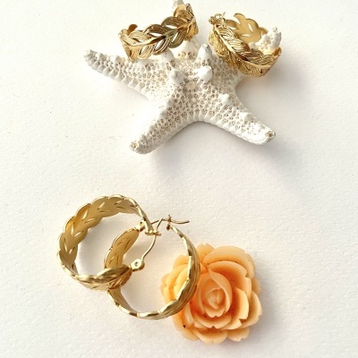 Anel dourado com padrão de folhas, argolas douradas, estrela-do-mar branca e flor pêssego