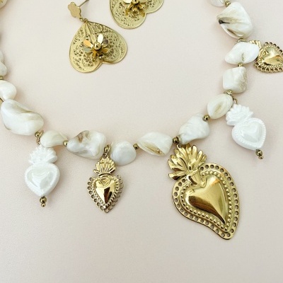 Colar e brincos com corações dourados e brancos sobre fundo claro