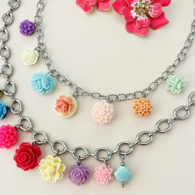 Colares e brincos com flores coloridas em metal prateado