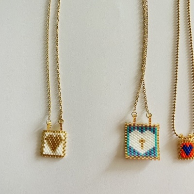 Três colares com pendentes quadrados de contas coloridas em correntes douradas