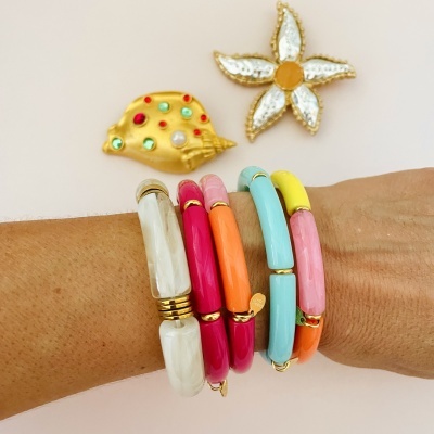 Pulseiras coloridas e broches decorativos com pedras sobre fundo branco