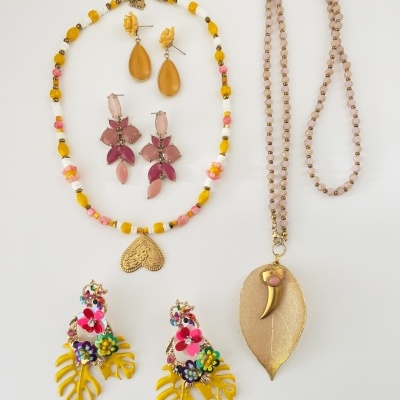 Colares e brincos coloridos e dourados sobre fundo branco