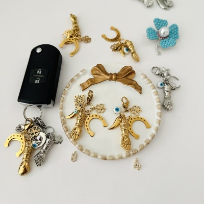 Conjunto de bijuteria com pendentes dourados e prateados e chaveiro preto