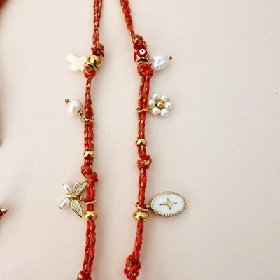 Colar com pendentes dourados e cordão vermelho trançado