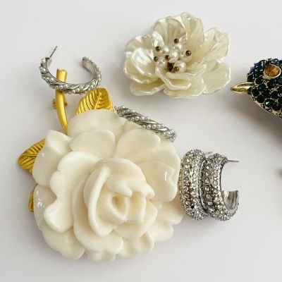 Bijutarias florais brancas com detalhes dourados e prateados em fundo branco