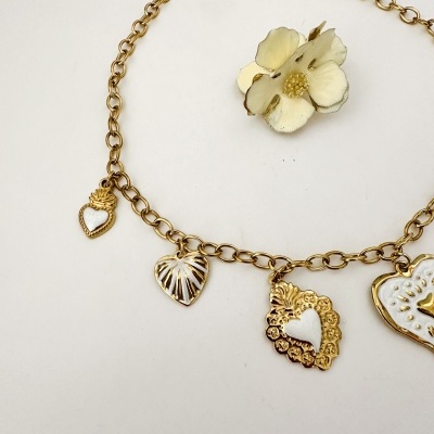 Colar dourado com pendentes em forma de coração e flor em branco e dourado