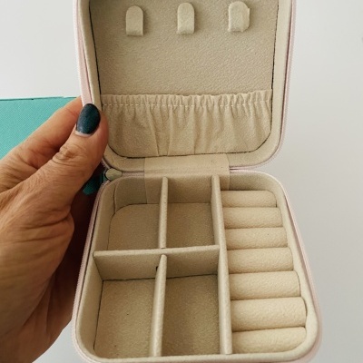 Caixa organizadora de joias rosa com interior bege e divisórias internas
