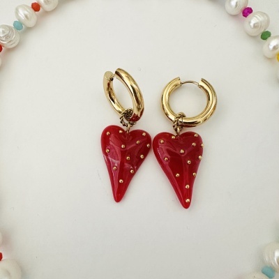 Brincos de argola dourada com coração vermelho brilhante e pontos dourados.