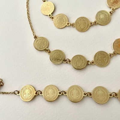 Três colares dourados com moedas redondas e relevo detalhado