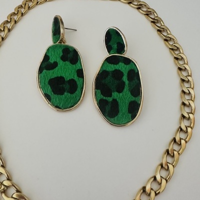 Colar dourado e brincos com padrão verde e preto
