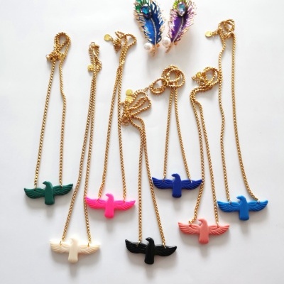 Colares dourados com pendentes de pássaros coloridos e brincos com penas coloridas