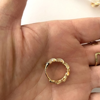 Argola dourada pequena em mão com textura rendilhada